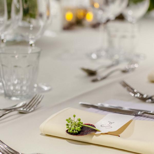 Elegant table setting with silver cutlery, cream tablecloth and crystal glassware