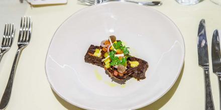 Gourmet dinner plated o a white plate with fine silver cutlery